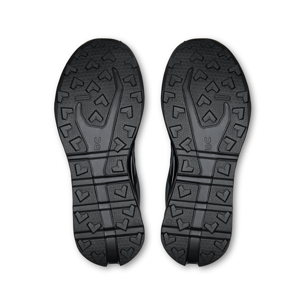 Pair of black shoe outsoles with grippy tread pattern and rugged traction lugs