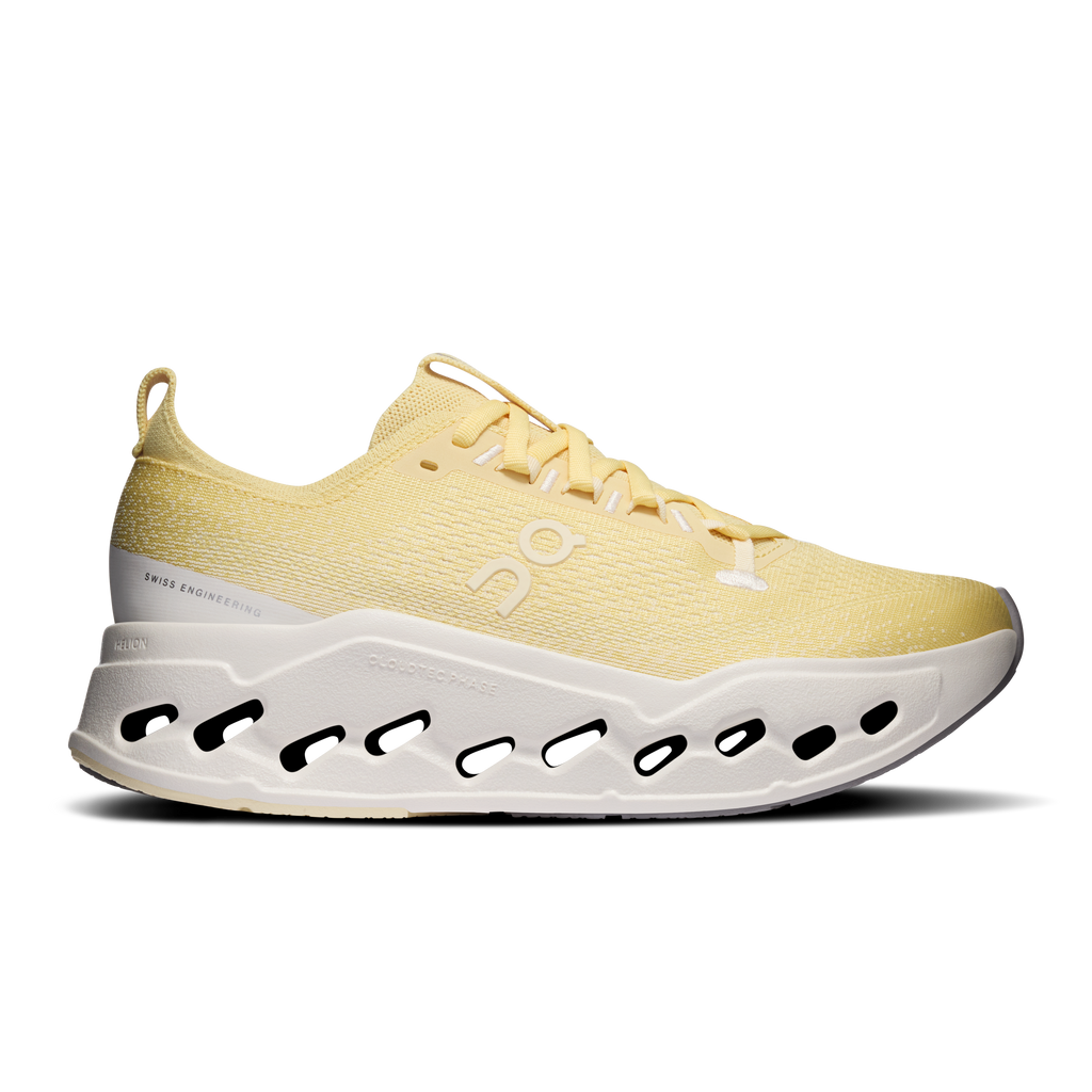 Women's yellow running shoes with white cushioned sole and black cutout pods