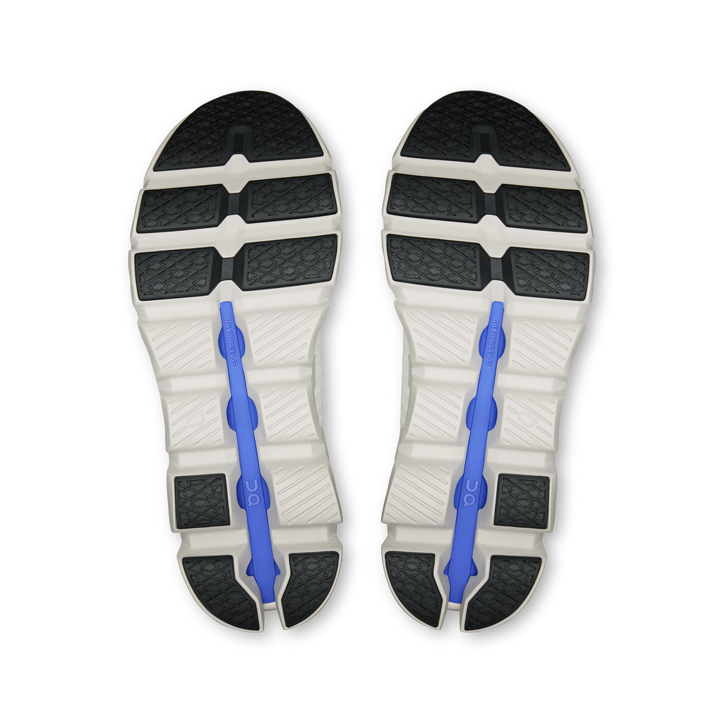 Shoe outsole view with dark tread sections and blue flex post inserts