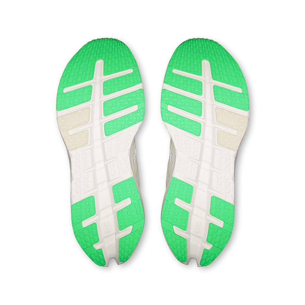 Pair of shoe outsoles with green tread and light panels for grip.