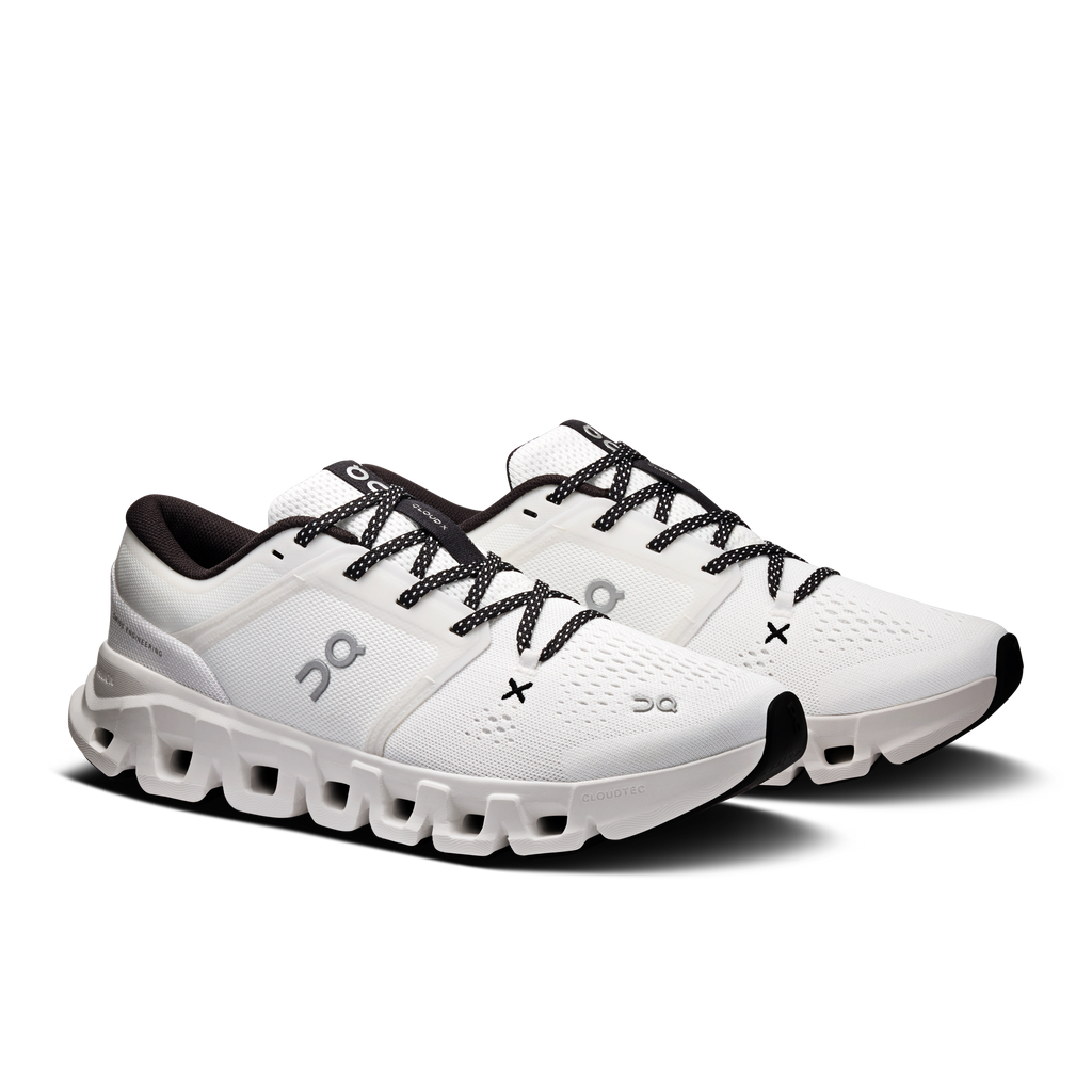 Women's white running shoes angled view with black lace-up and chunky sole