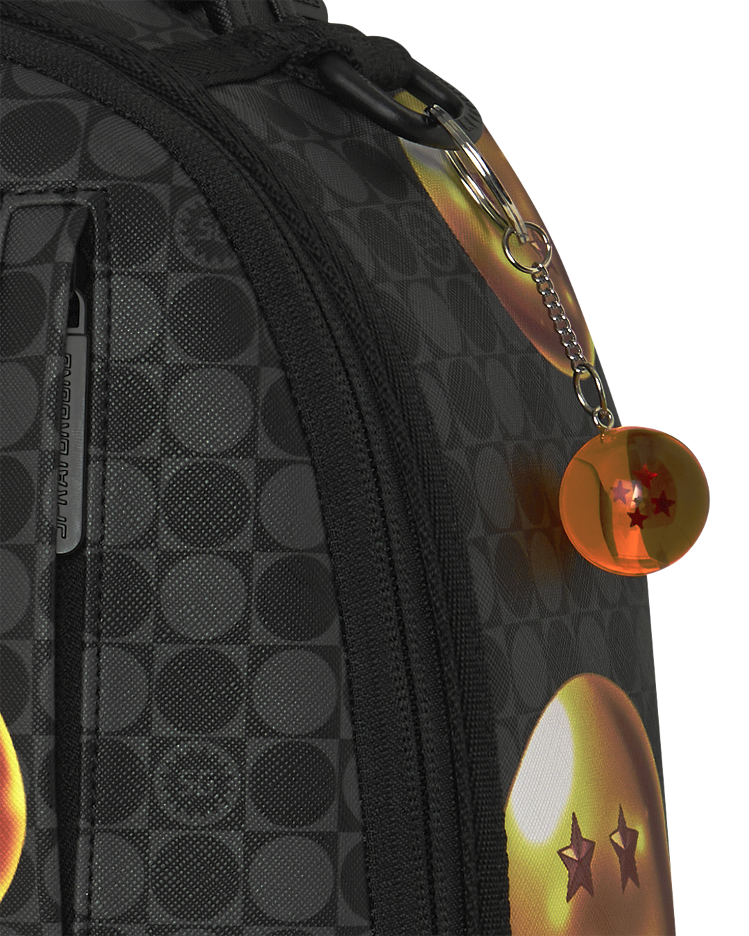 Black backpack side panel with textured pattern, zipper, and round orange keychain charm