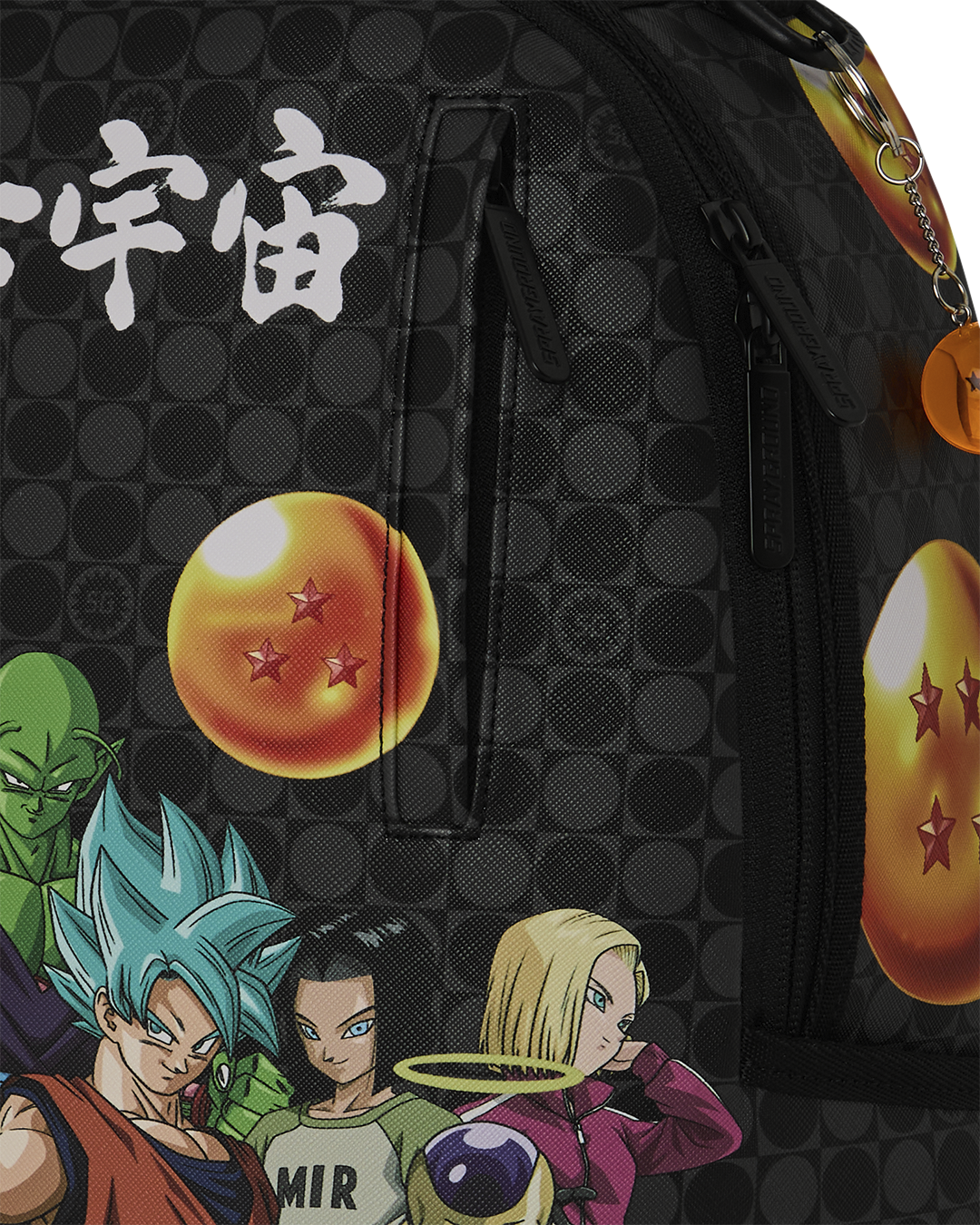 Black patterned backpack with large white character text, dragon-themed charm discs, and zipper