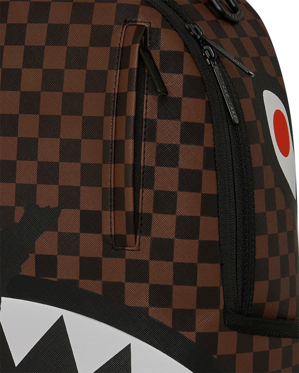 Close-up of brown checkered backpack fabric with black zipper and trim