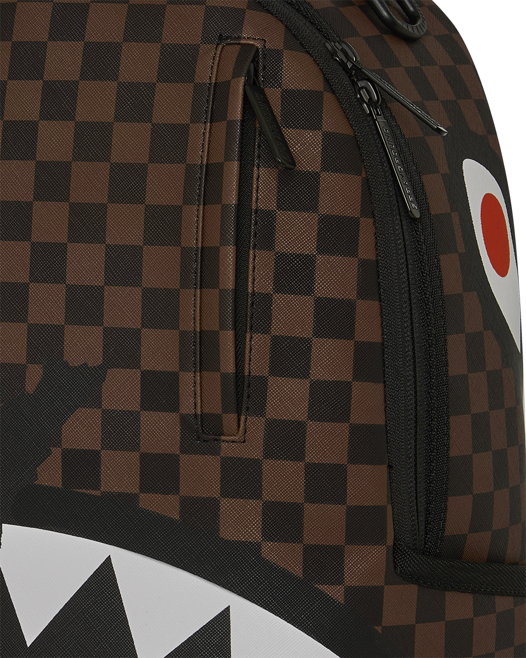 Close-up of brown checkered backpack fabric with black zipper and trim