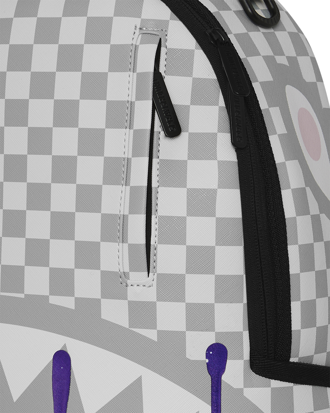 Checkered backpack close-up with black strap and stitched front pocket panel.