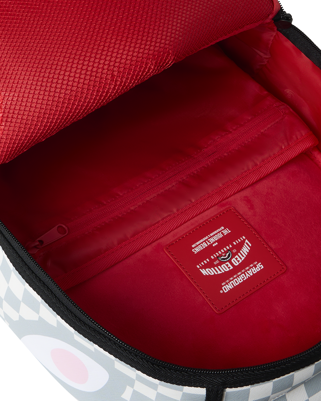 Cosmic Chaos backpack interior with red lining, zipper, and logo patch