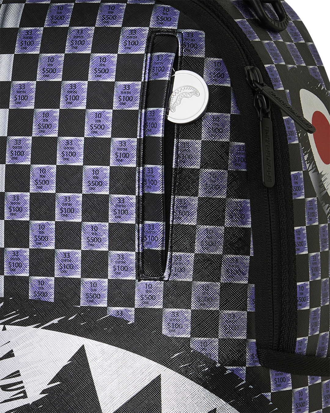 Sprayground shark backpack close-up of checkered fabric with small $100 print and zipper trim