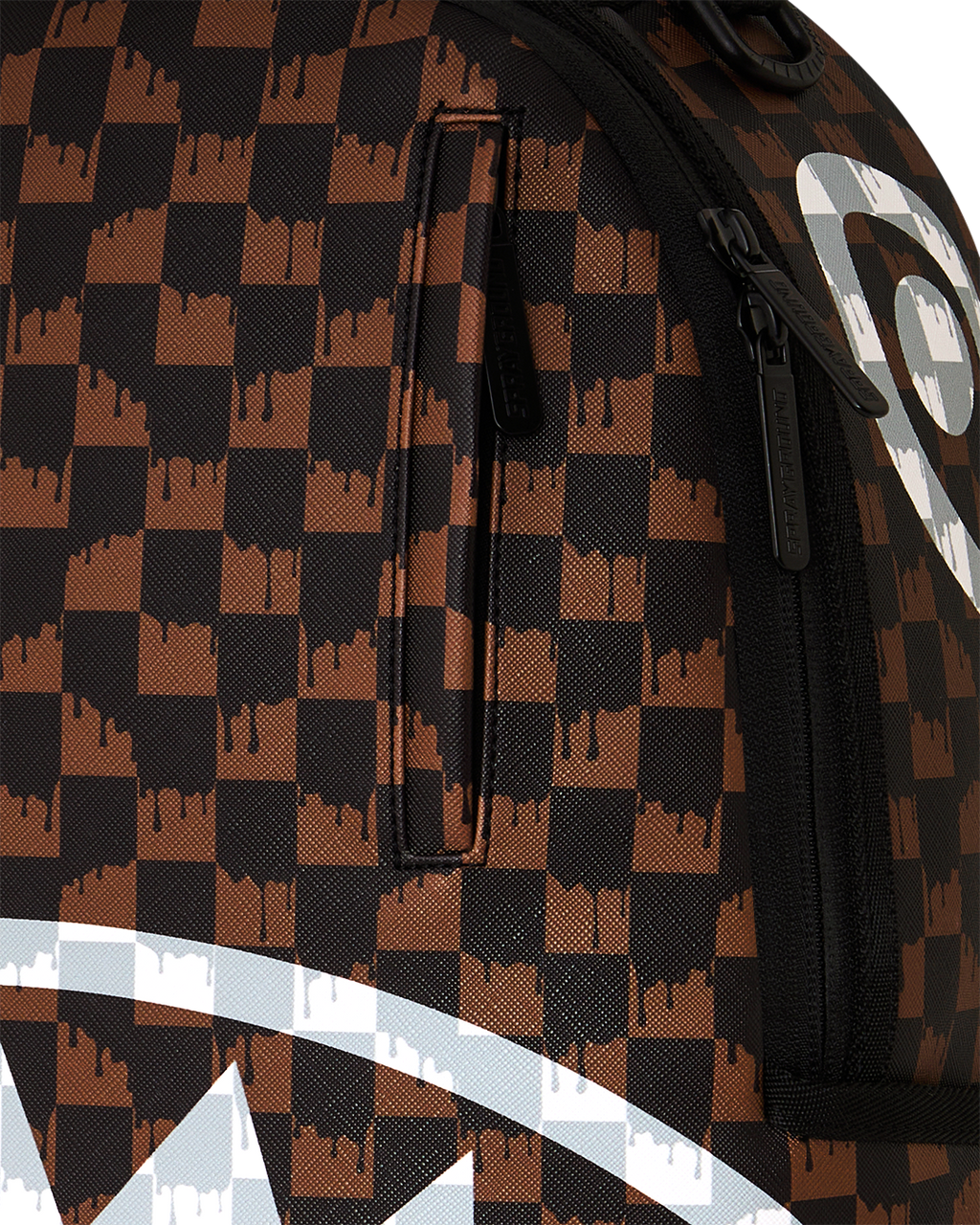 Brown checkered backpack close-up with black zipper and white stripe graphic