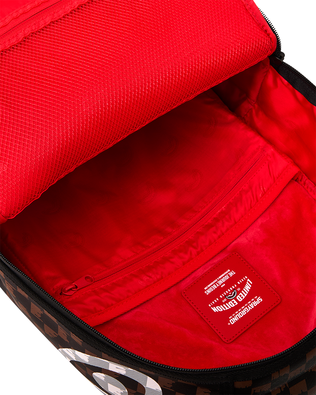Open backpack showing bright red interior lining and inner logo patch