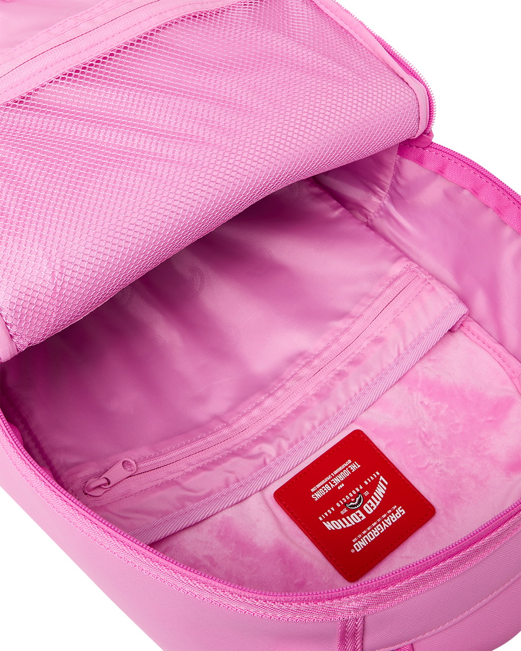 Pink backpack bag open with lined interior, inner zip pocket, and logo label