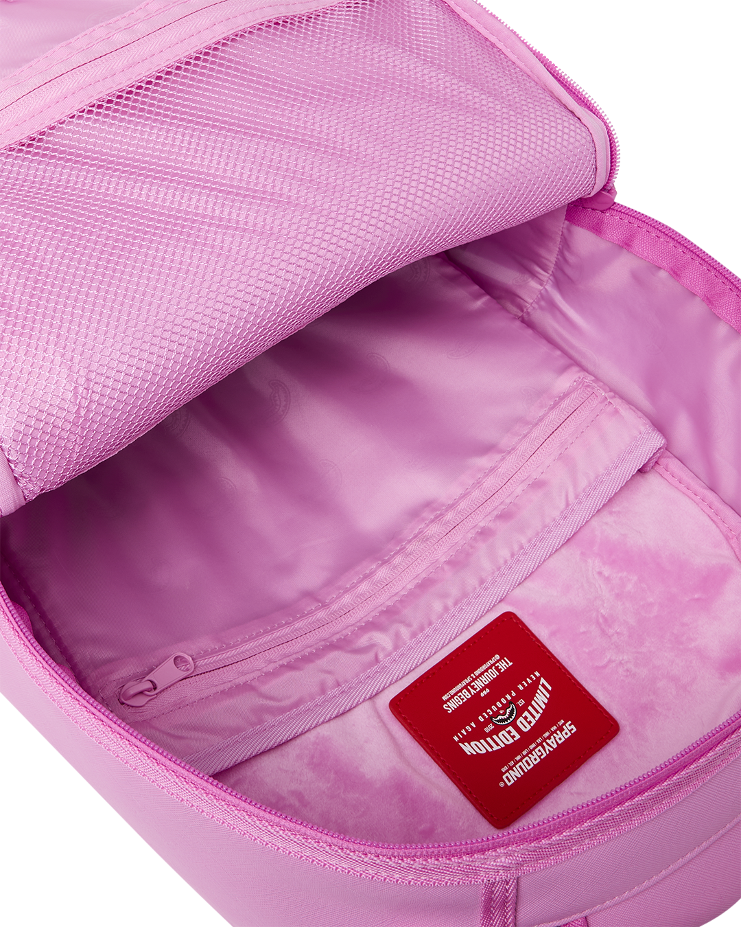 Pink backpack bag open with lined interior, inner zip pocket, and logo label
