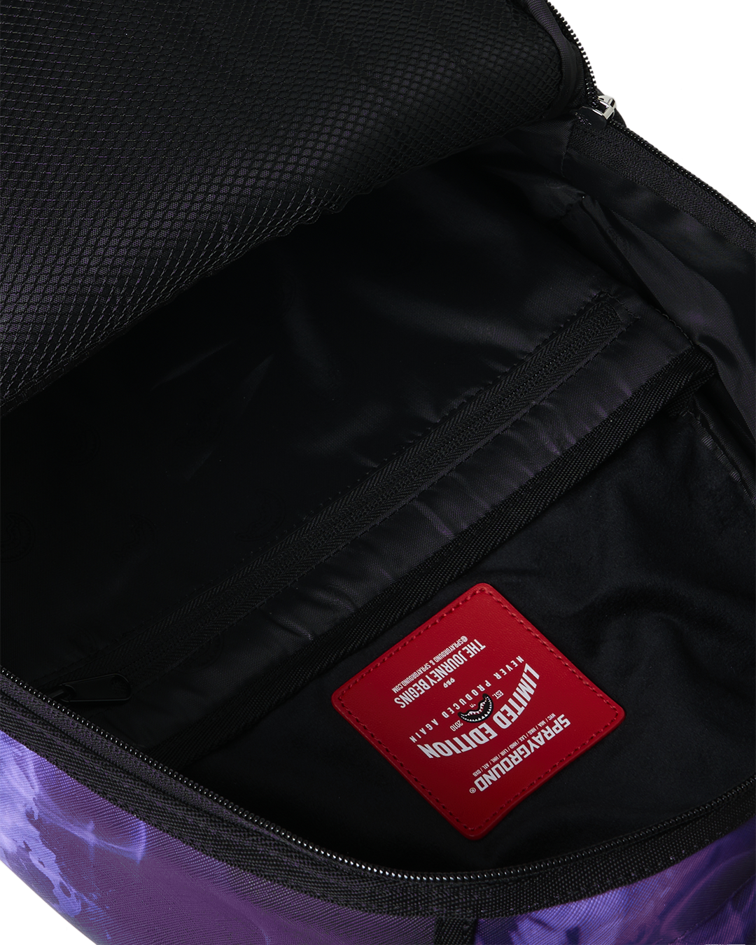 Open backpack bag interior with black lining and red brand patch