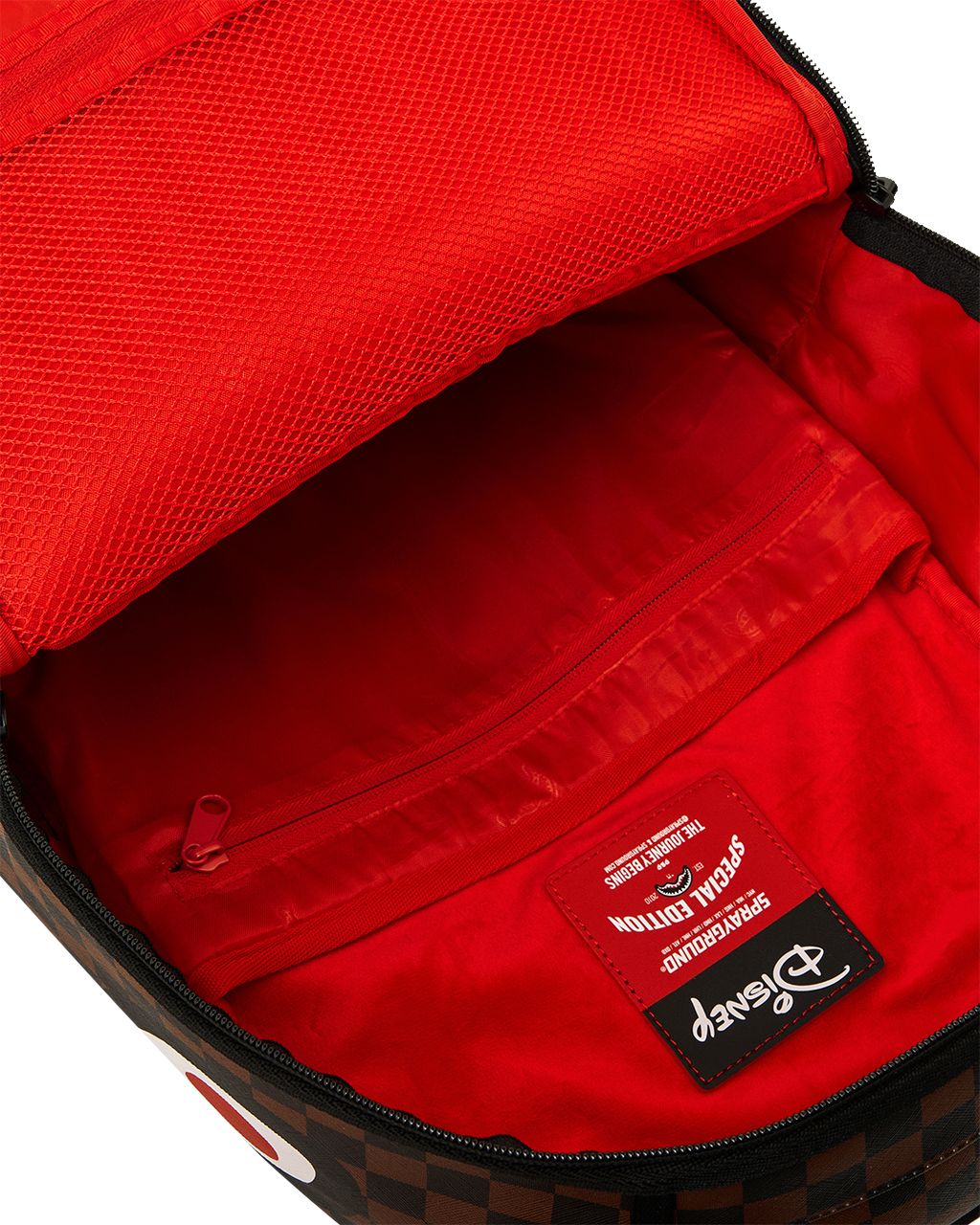 Backpack interior with red lining and zippered pocket, black trim