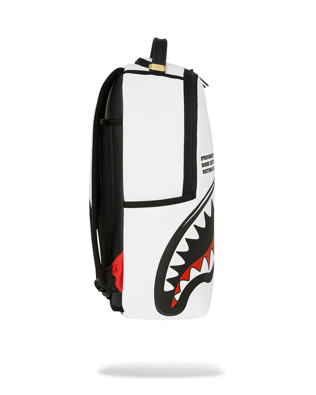 White and black backpack with shark artwork on side panel and black shoulder straps