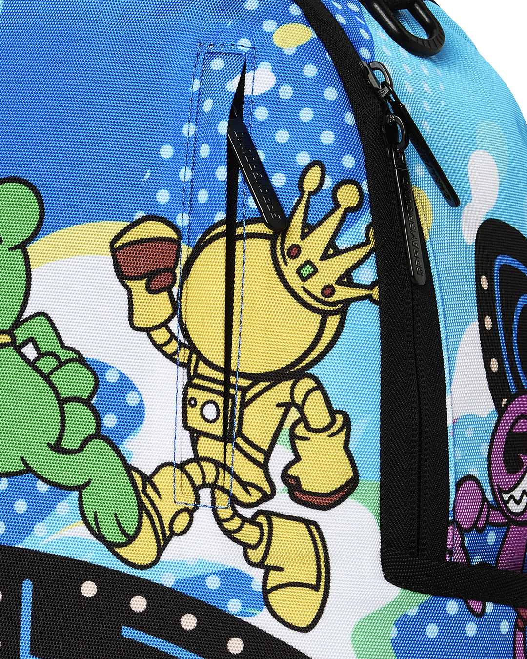 Close-up of blue backpack fabric with cartoon Pac-Man character print and zipper.