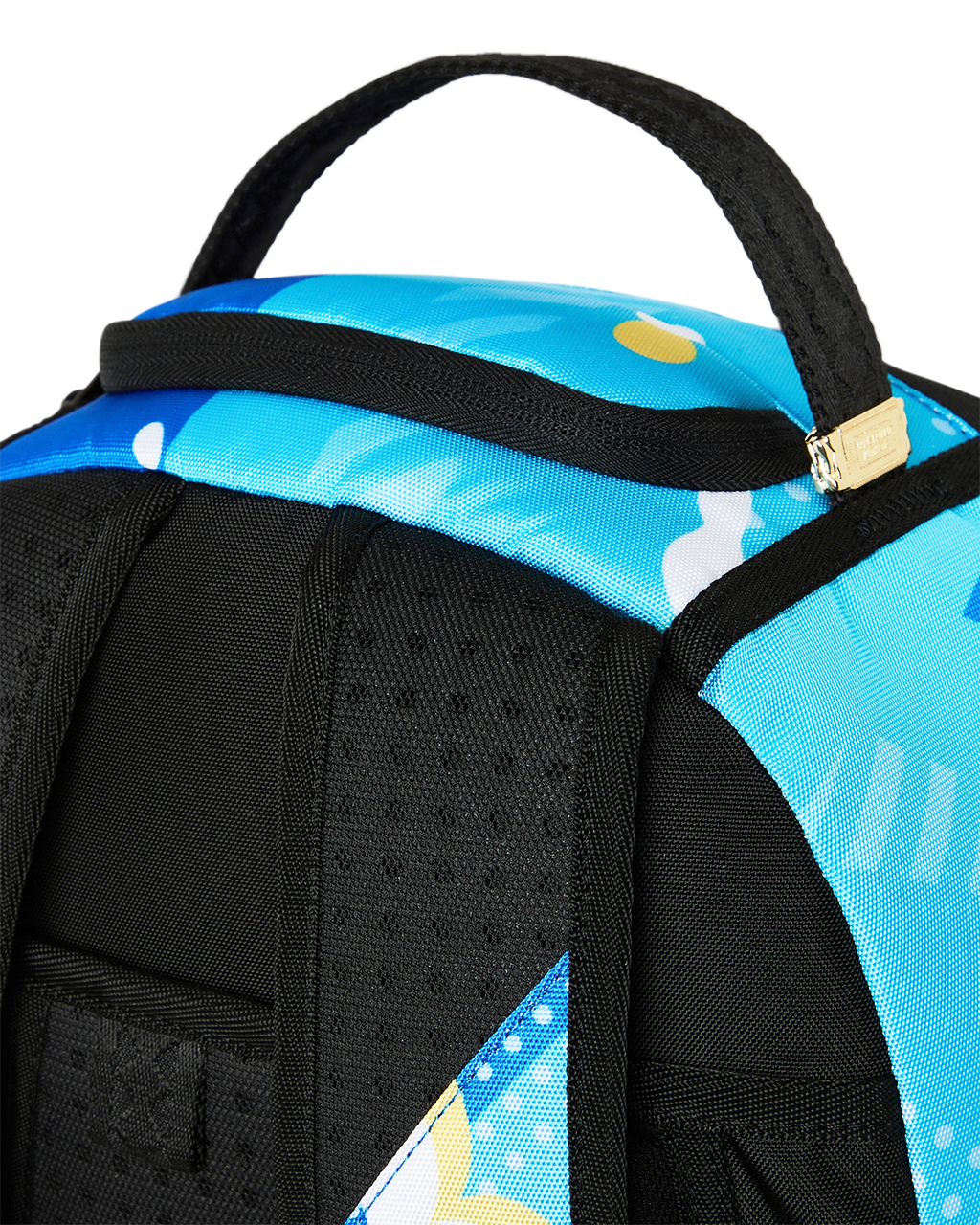 Close-up of blue backpack top handle and black padded shoulder strap.