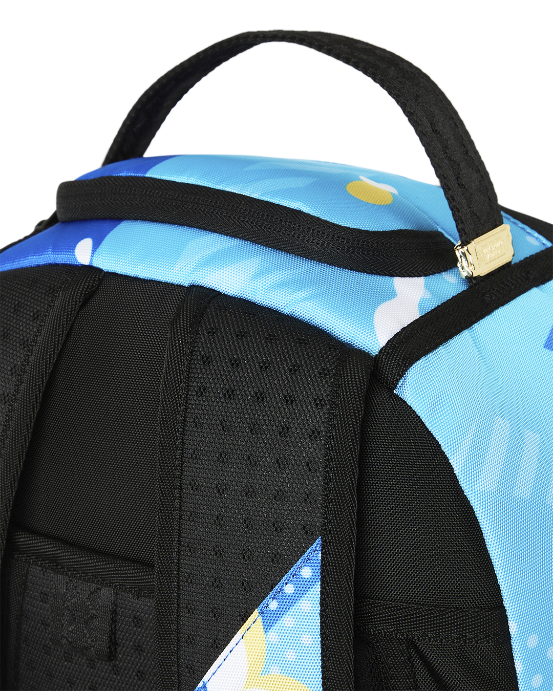 Close-up of blue backpack top handle and black padded shoulder strap.