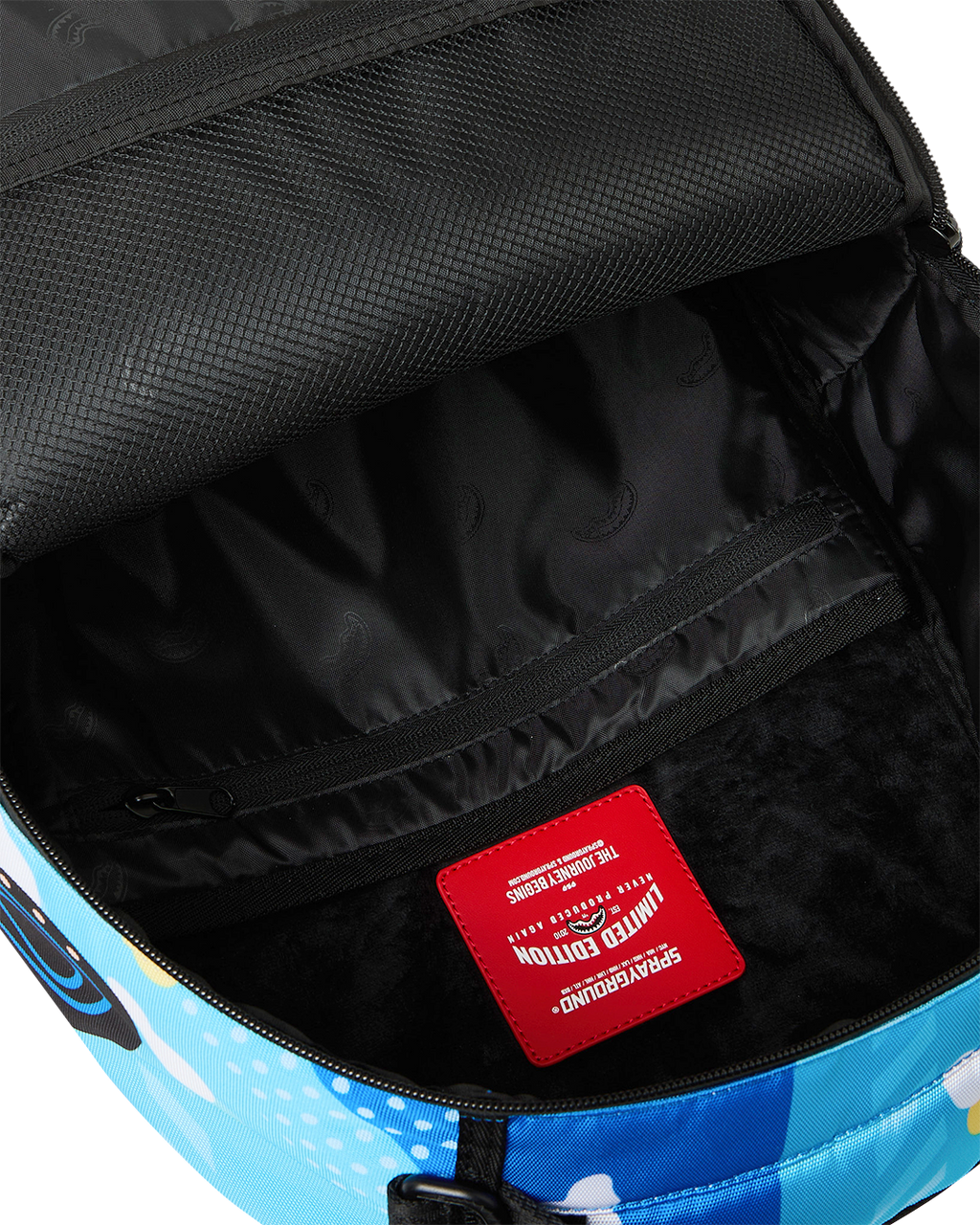 Backpack interior showing black lining and red fabric brand patch label.
