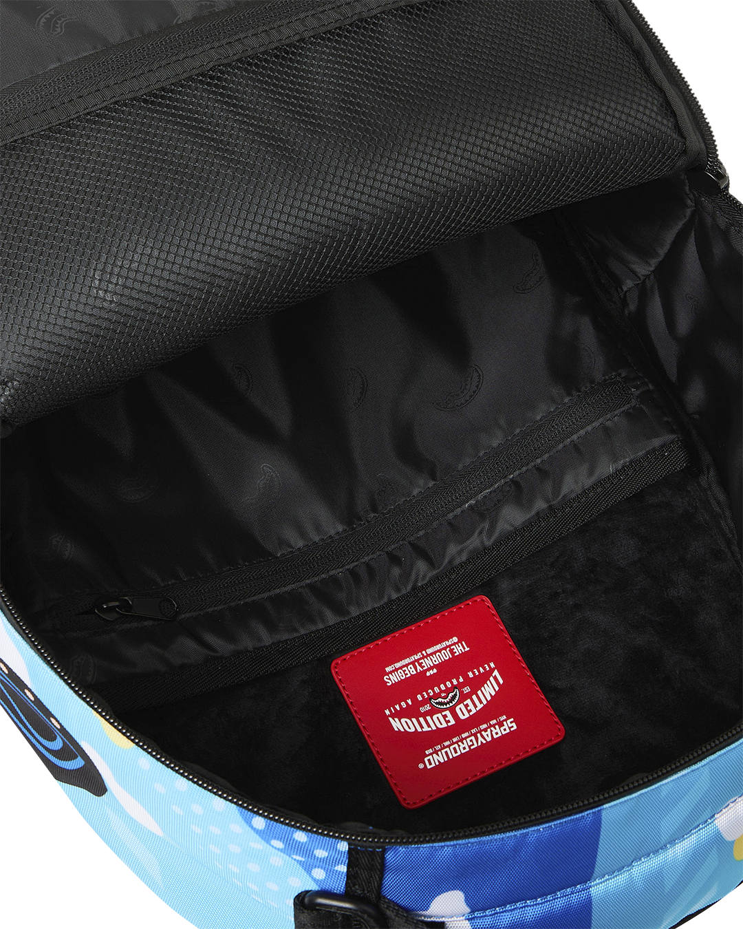 Backpack interior showing black lining and red fabric brand patch label.
