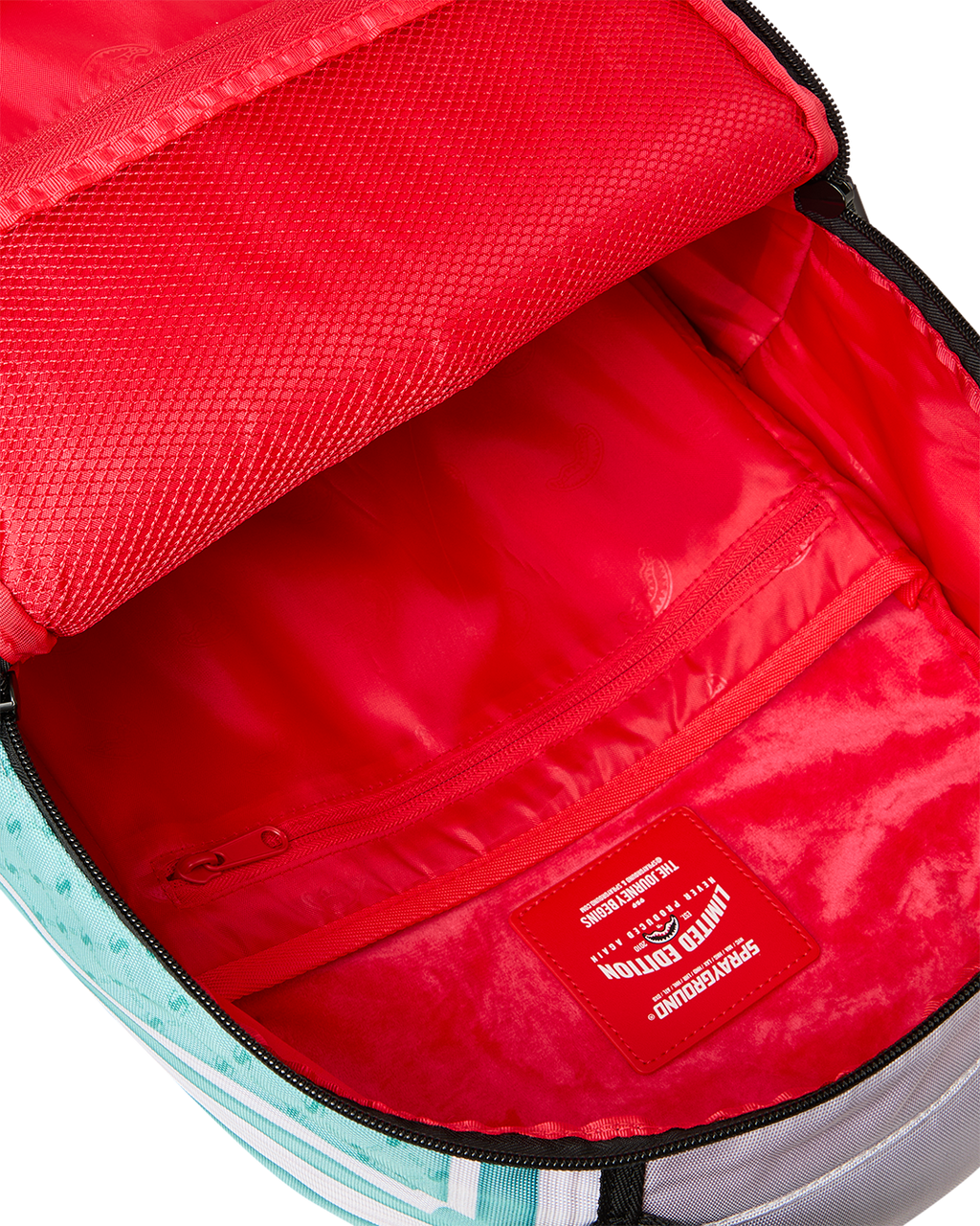 Red-lined backpack interior with zip pocket and label on inner bag wall