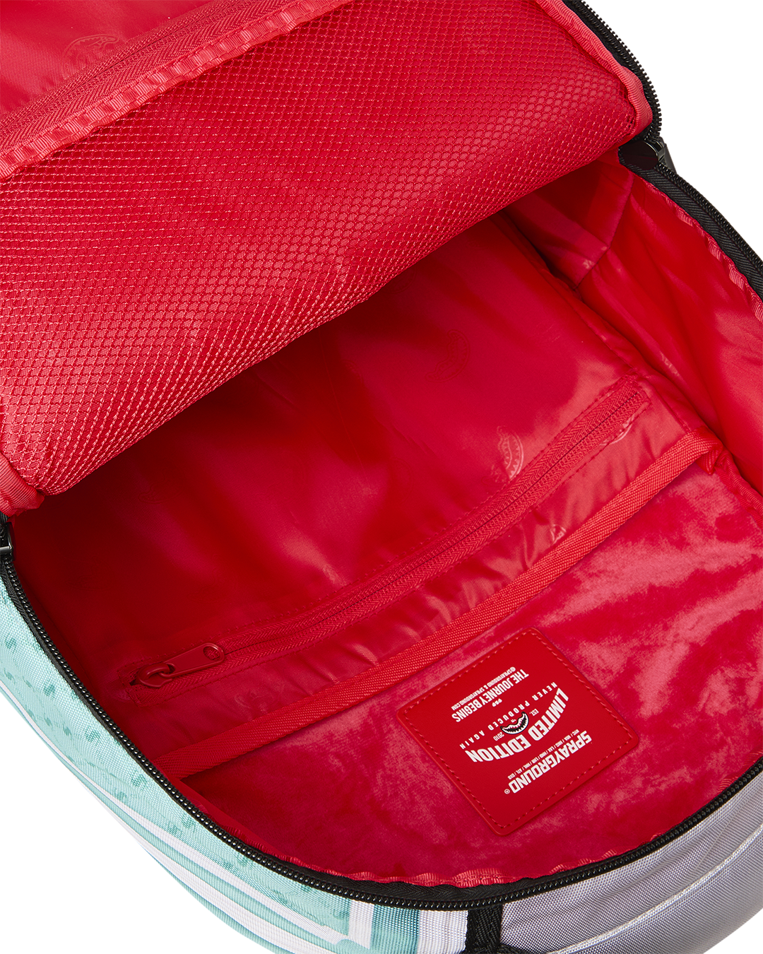 Red-lined backpack interior with zip pocket and label on inner bag wall