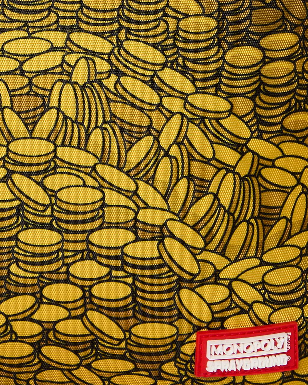 Close-up of yellow coin-pattern fabric with Monopoly Sprayground label