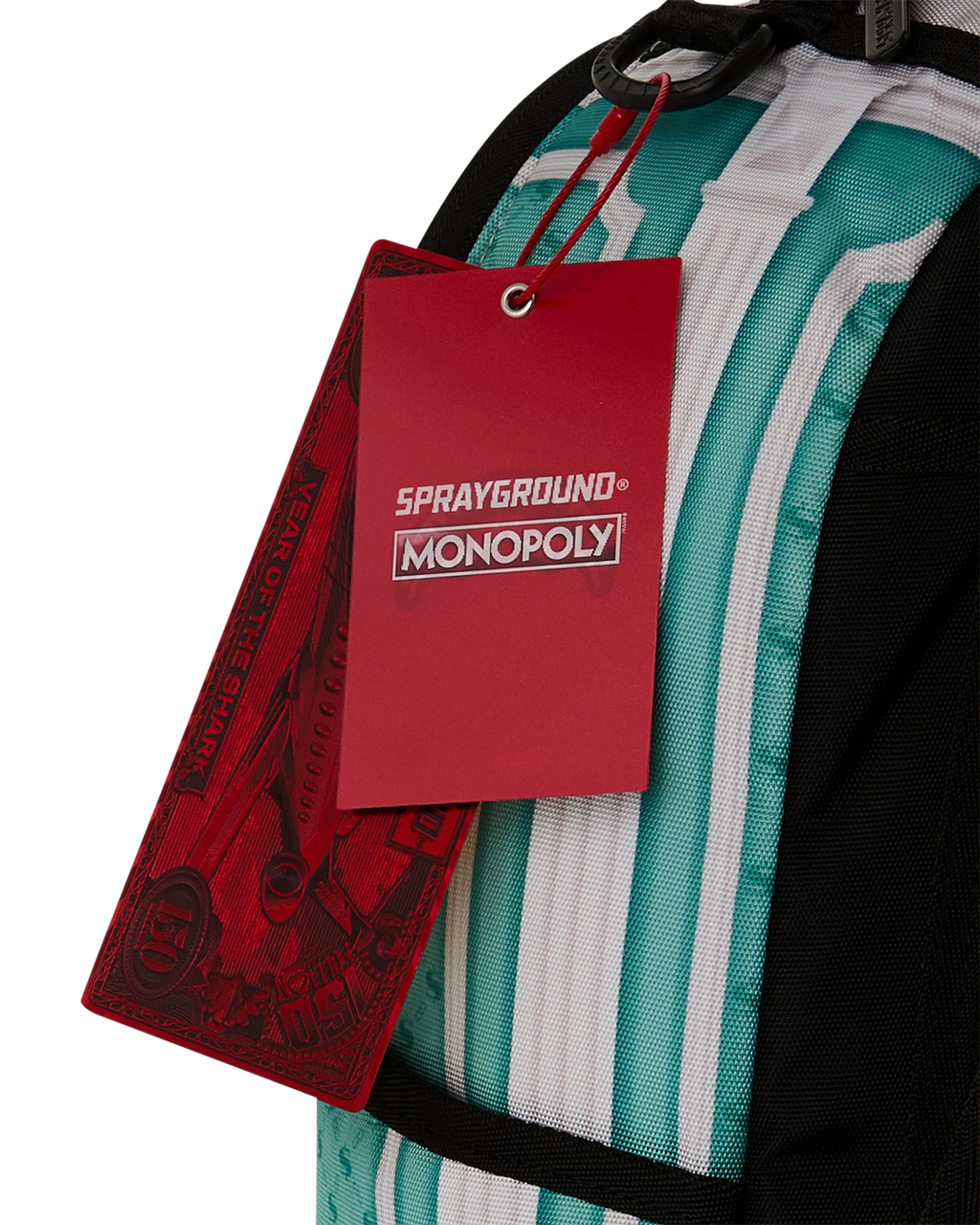 Backpack bag with red tag and black handle strap over teal-and-white stripes