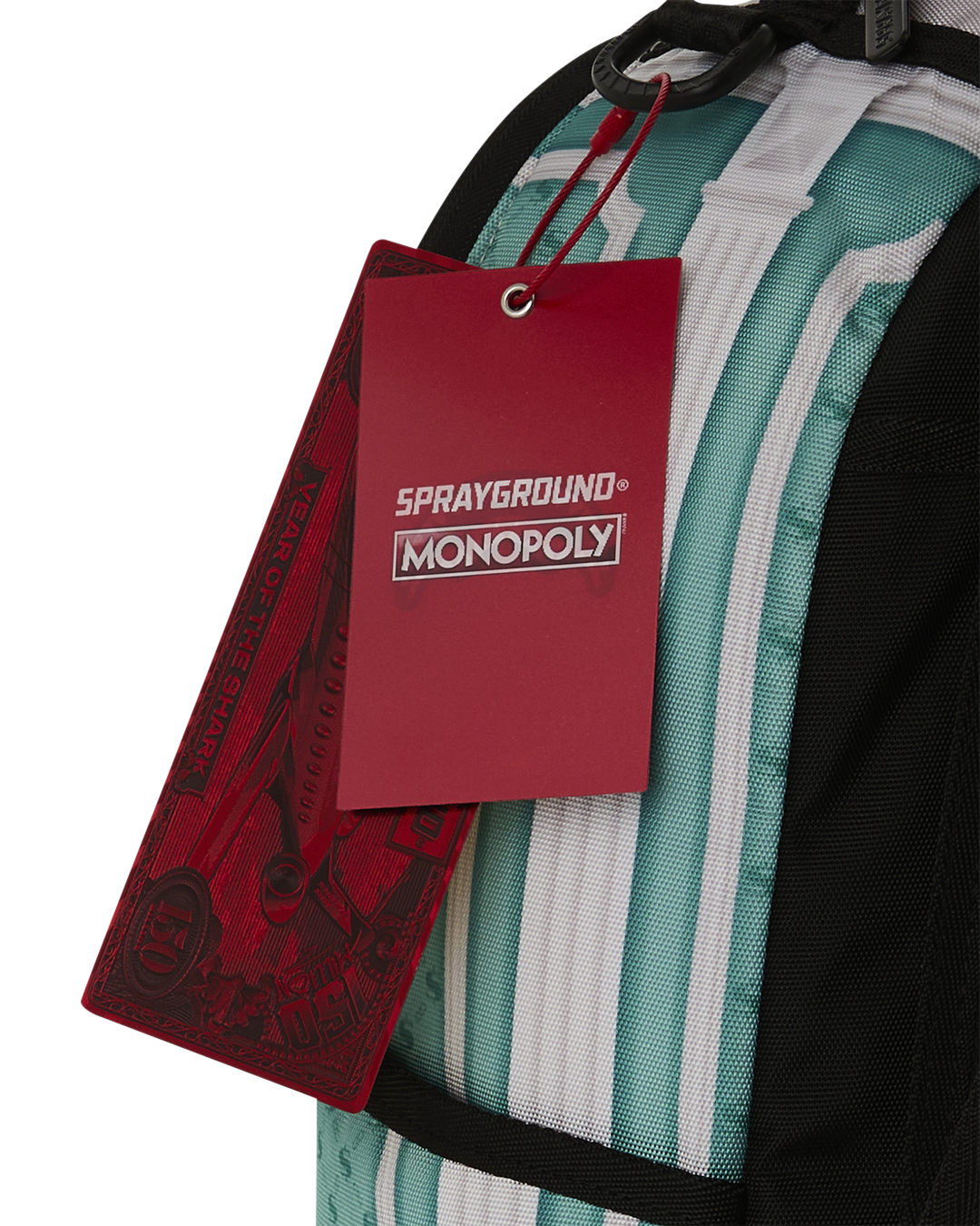 Backpack bag with red tag and black handle strap over teal-and-white stripes