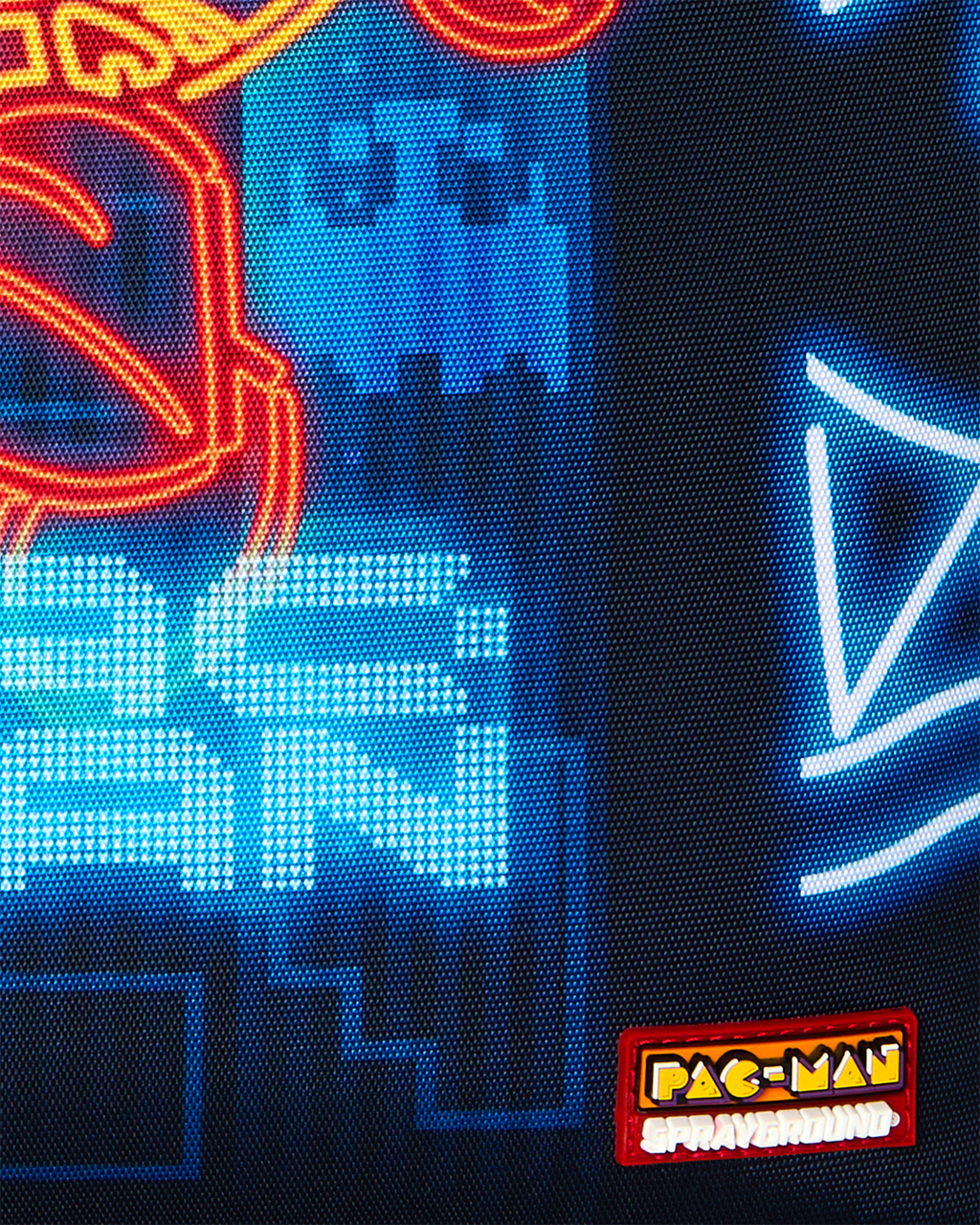 Pac-Man Eat Em Up backpack close-up of neon blue pixel art and Pac-Man logo patch