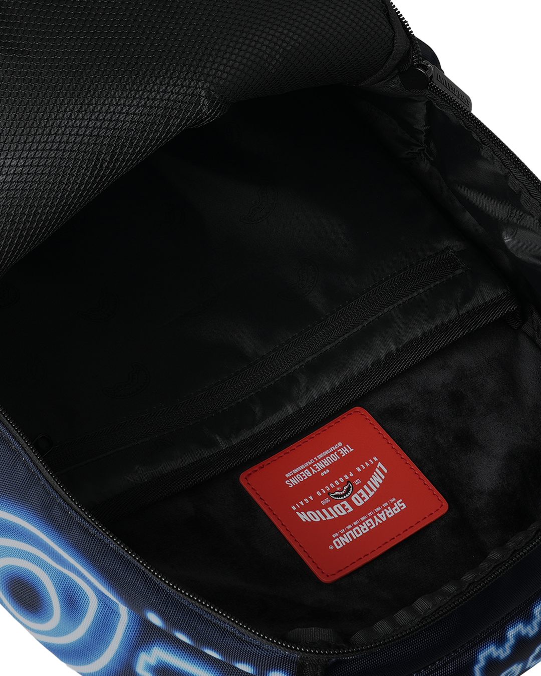 Backpack interior pocket with red brand label and black lining, zipper visible
