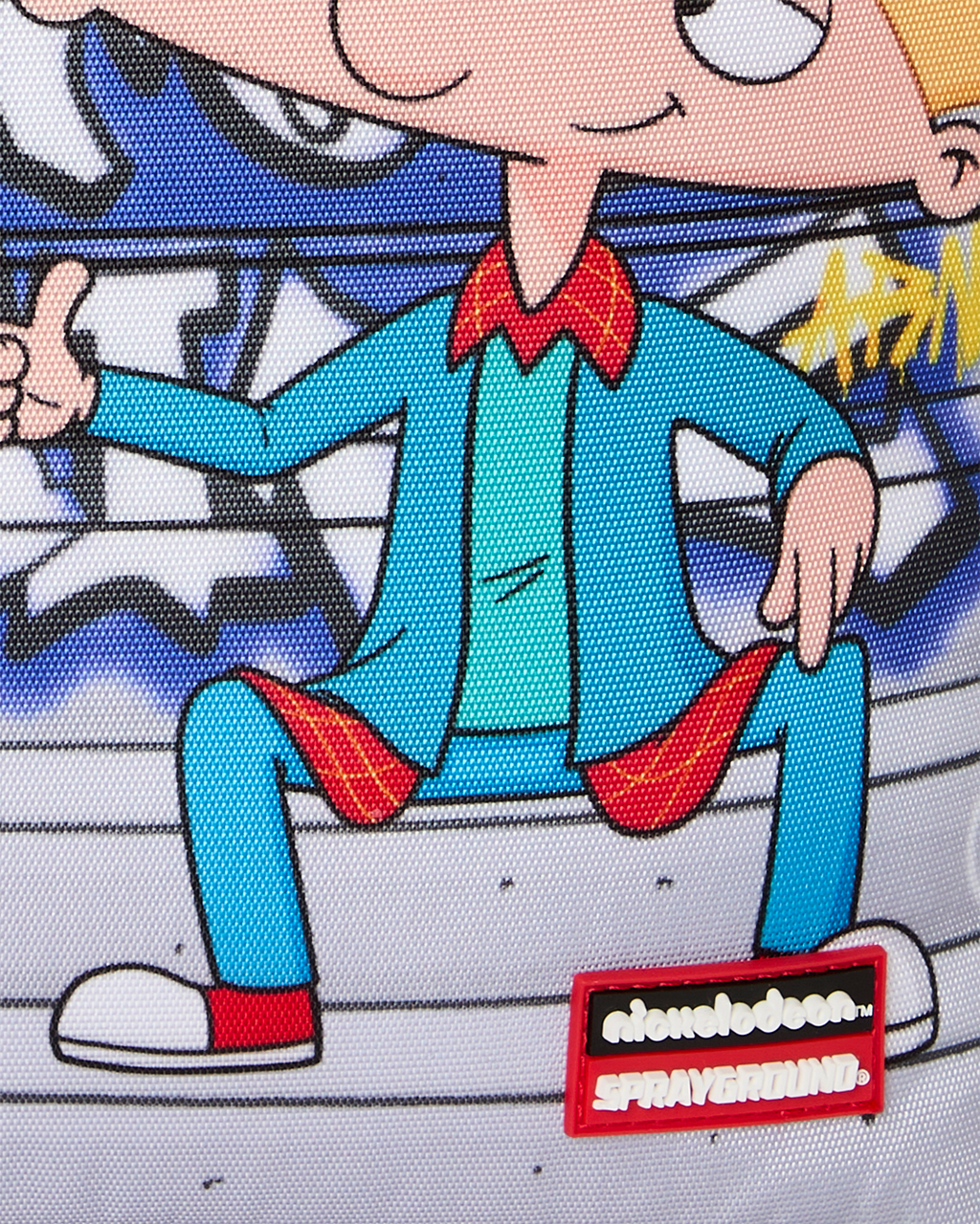 Kids backpack front detail with cartoon boy illustration and Sprayground logo patch