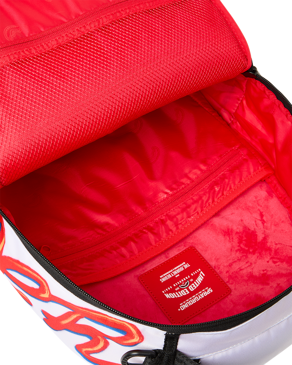 Red-lined mini backpack compartment with black-trim zipper and inner logo tag