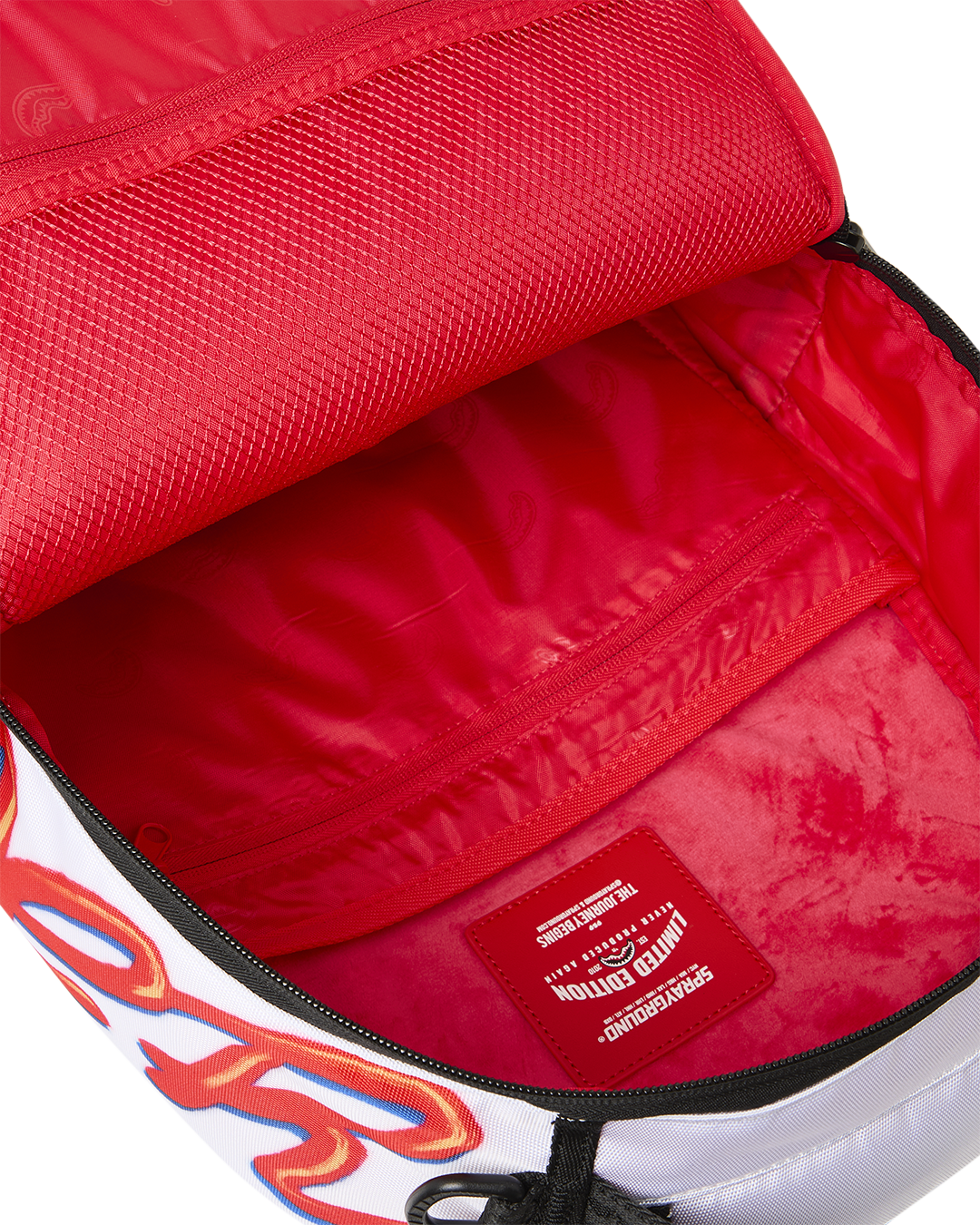 Red-lined mini backpack compartment with black-trim zipper and inner logo tag