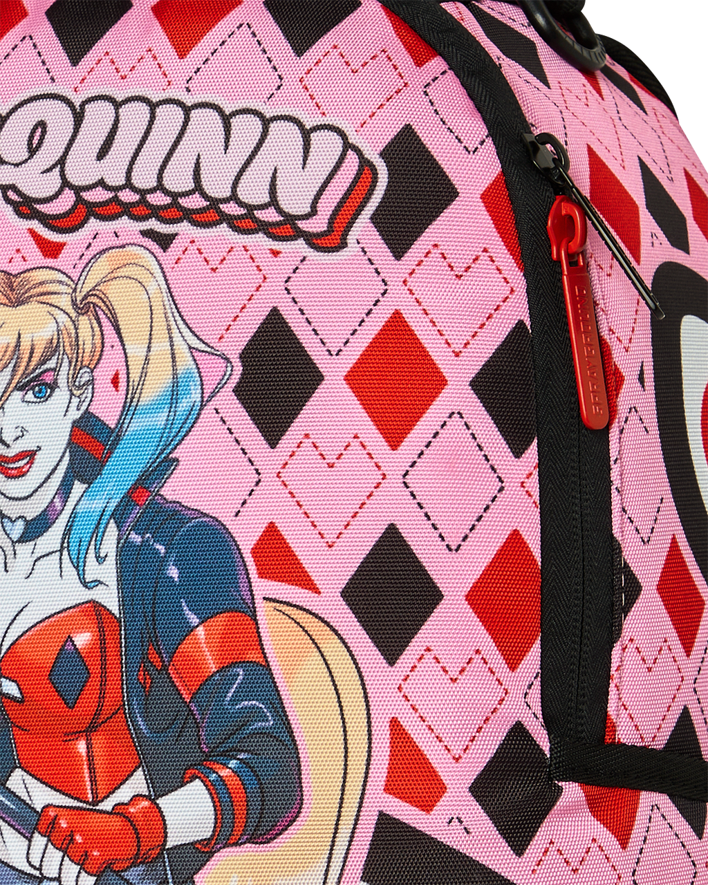 Harley Quinn backpack fabric close-up with red emblem detail on pink patterned design.