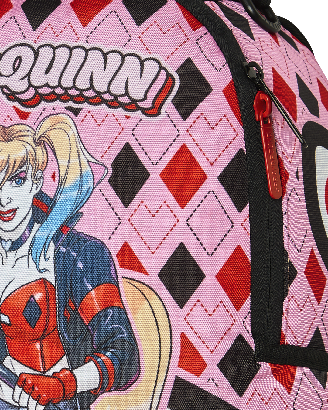 Harley Quinn backpack fabric close-up with red emblem detail on pink patterned design.