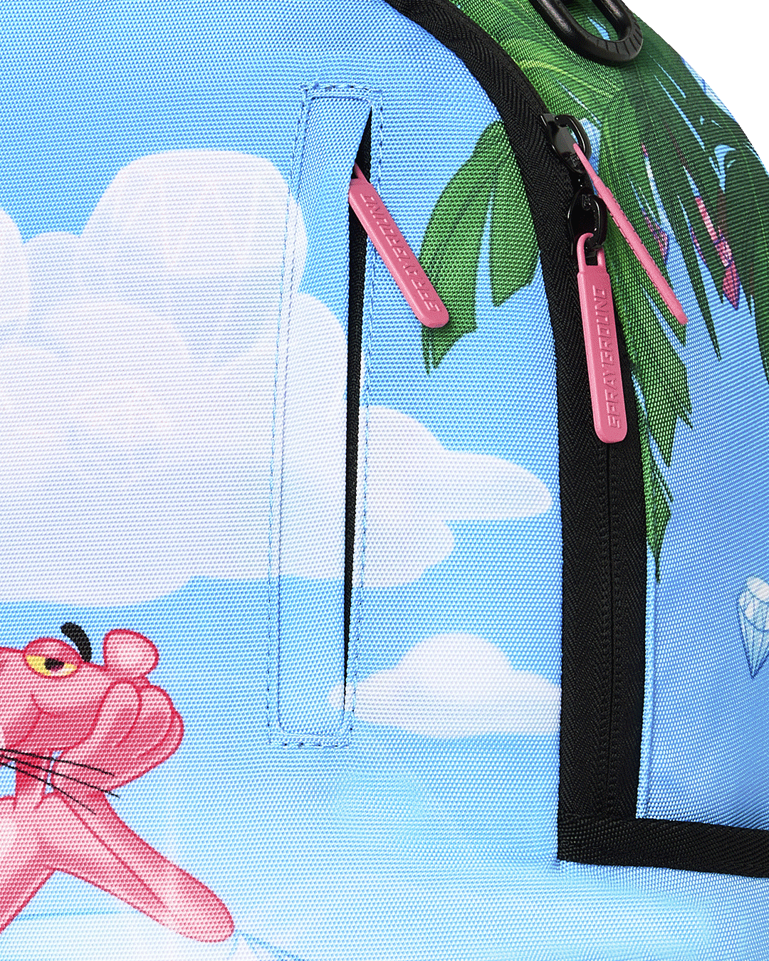 Close-up of blue backpack zipper with pink pull tab and jungle leaf side panel