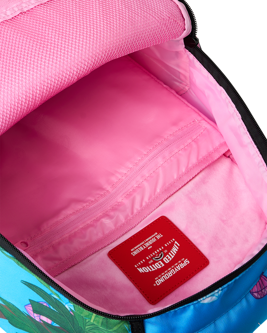 Backpack interior with pink lining and red branded patch near the zipper