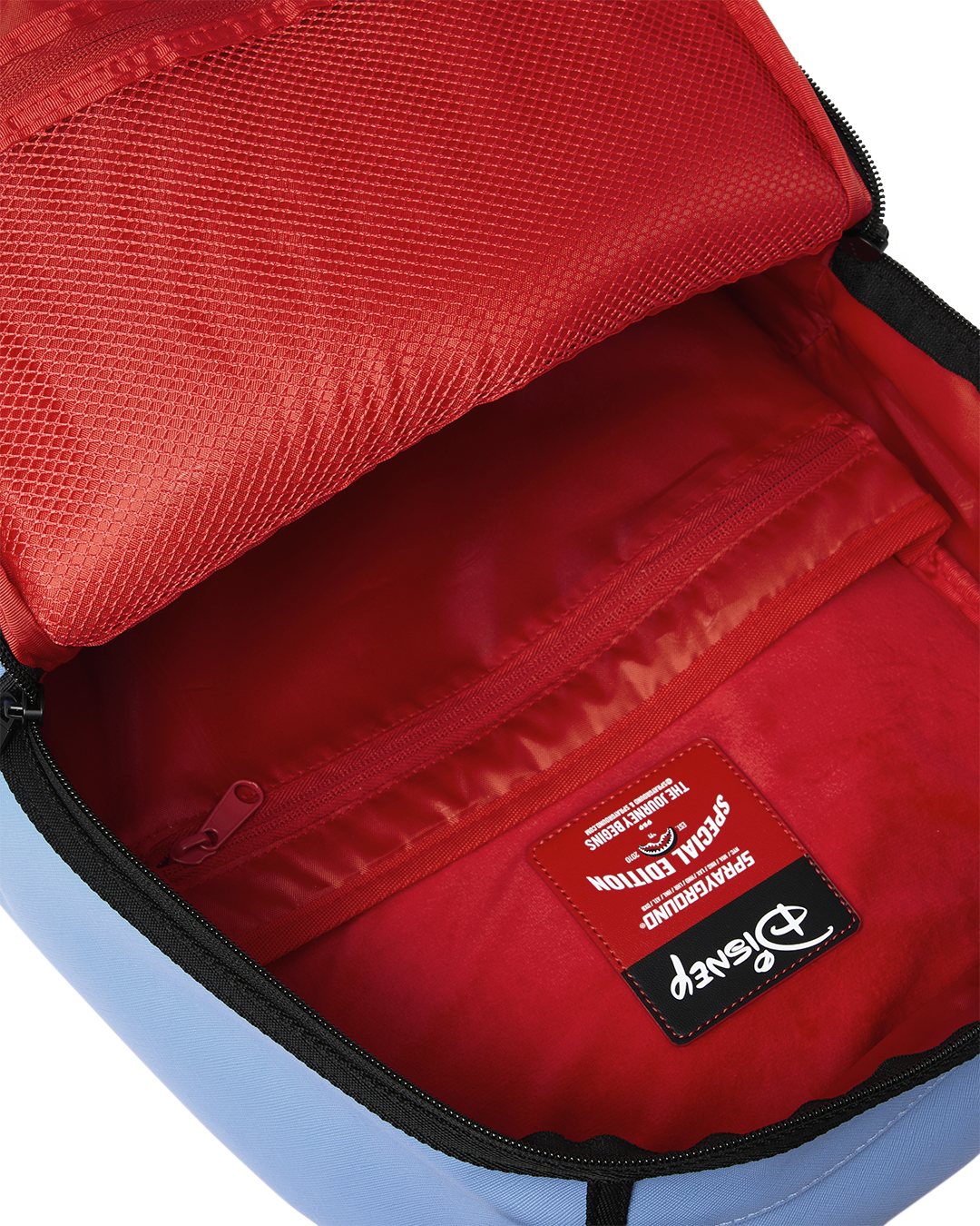 Red-lined main compartment with zip pocket and fabric tag inside backpack