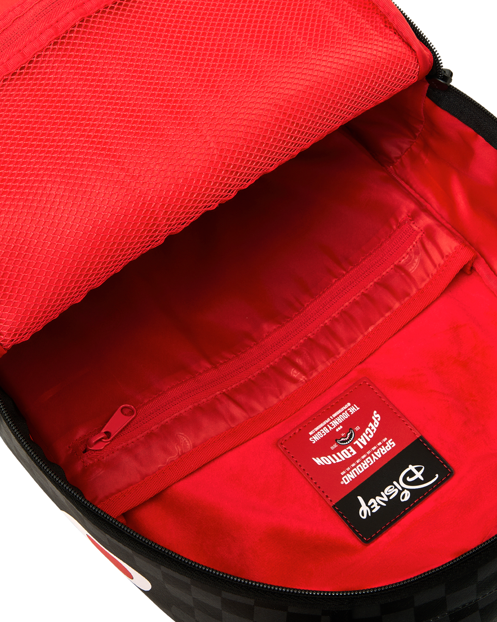 Backpack interior with bright red lining and zippered mesh pocket