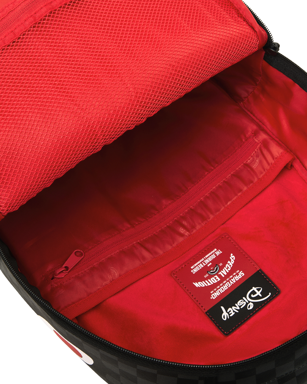 Backpack interior with bright red lining and zippered mesh pocket