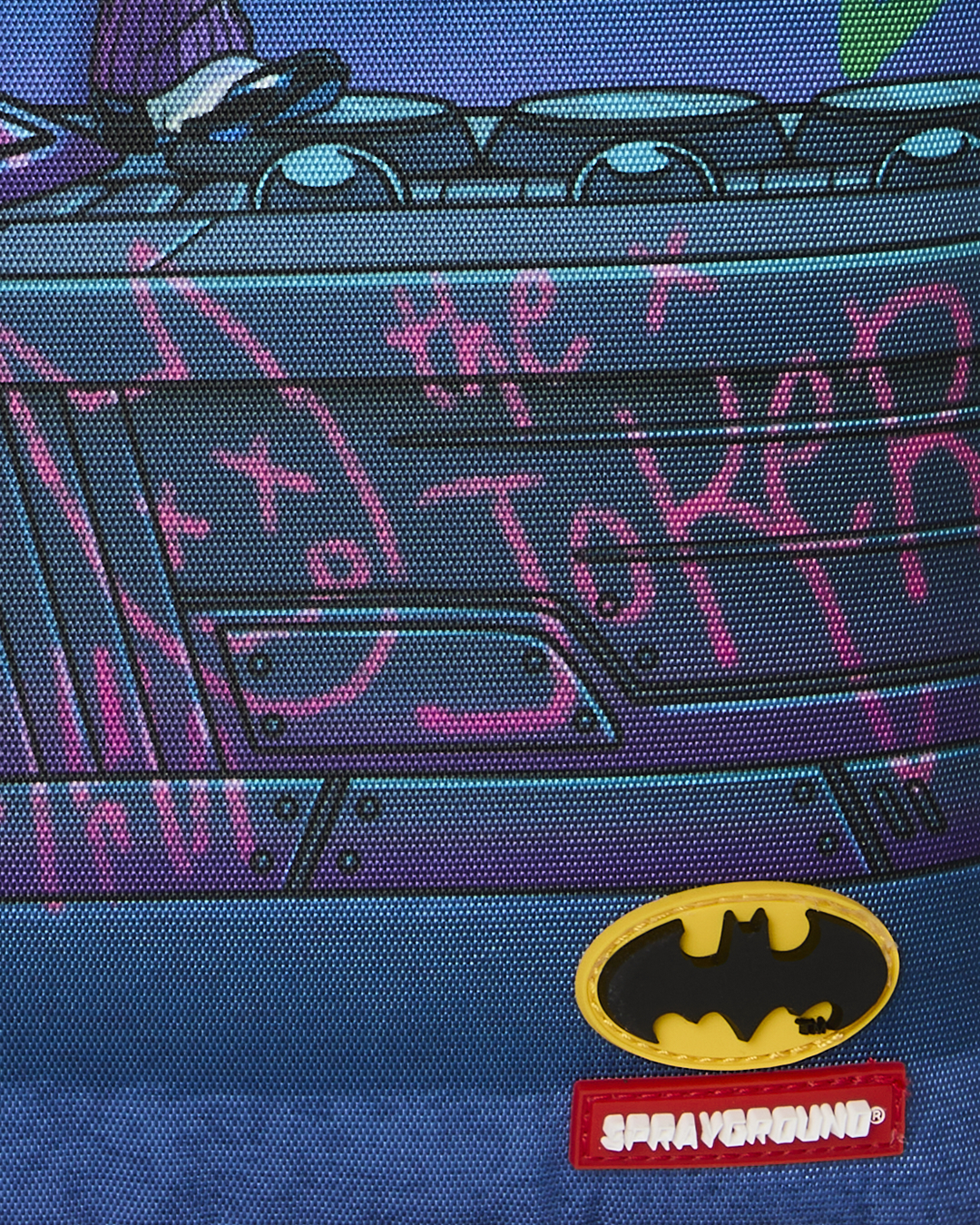 Close-up of Batman logo and red brand patch on blue Joker graphic