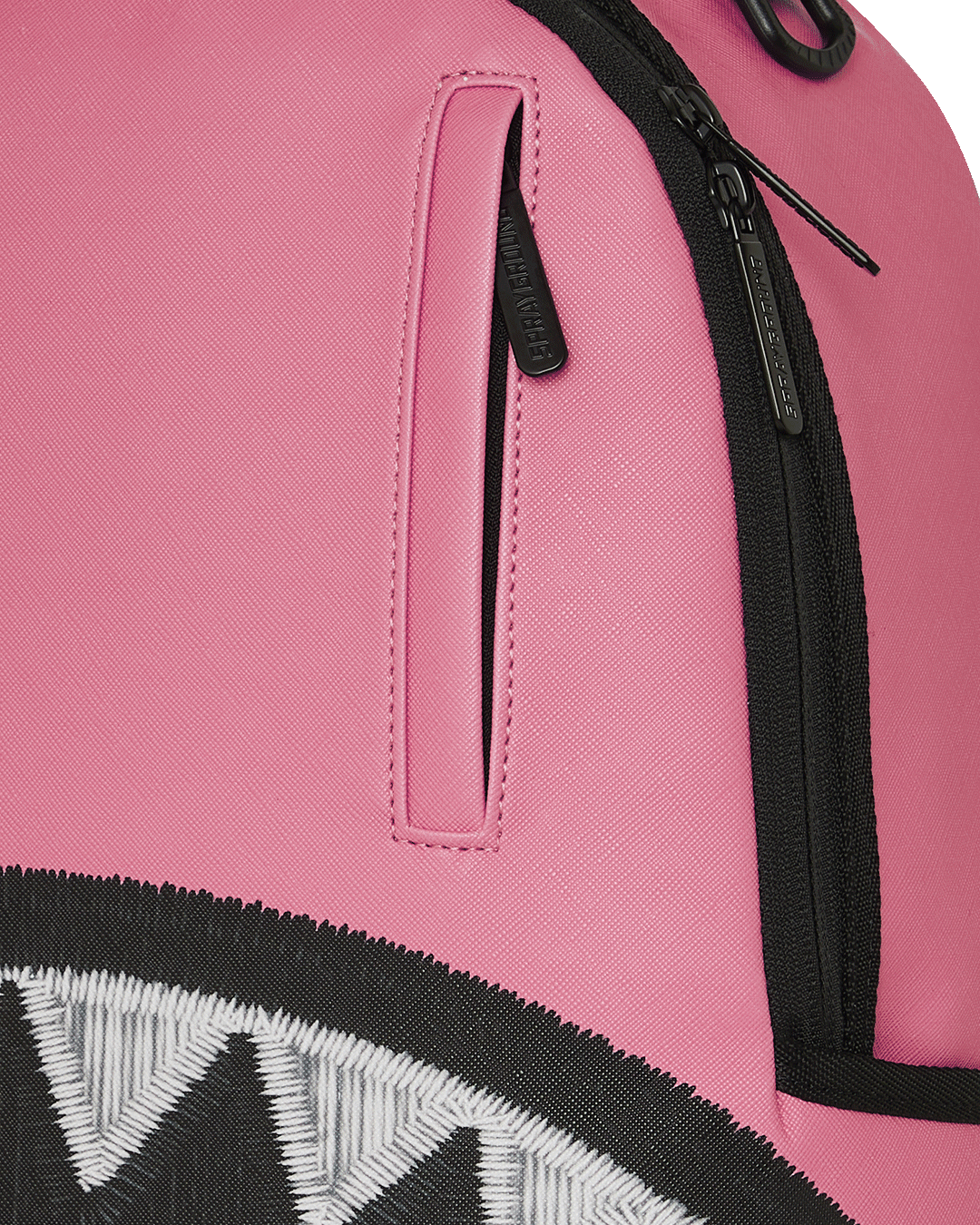 Pink backpack close-up: black zipper and vertical side pocket on front panel