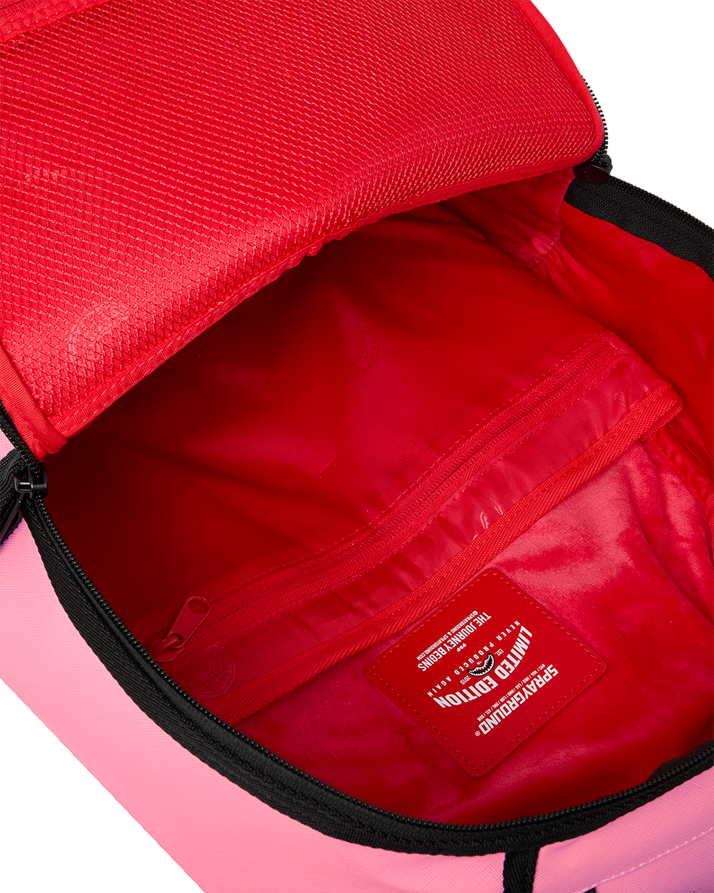 Pink backpack with red interior, zip pocket, and stitched brand patch