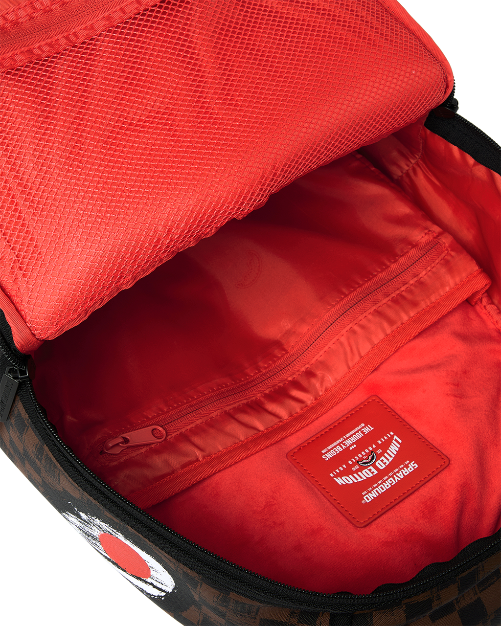 Sprayground backpack open top showing red interior lining and zip pocket