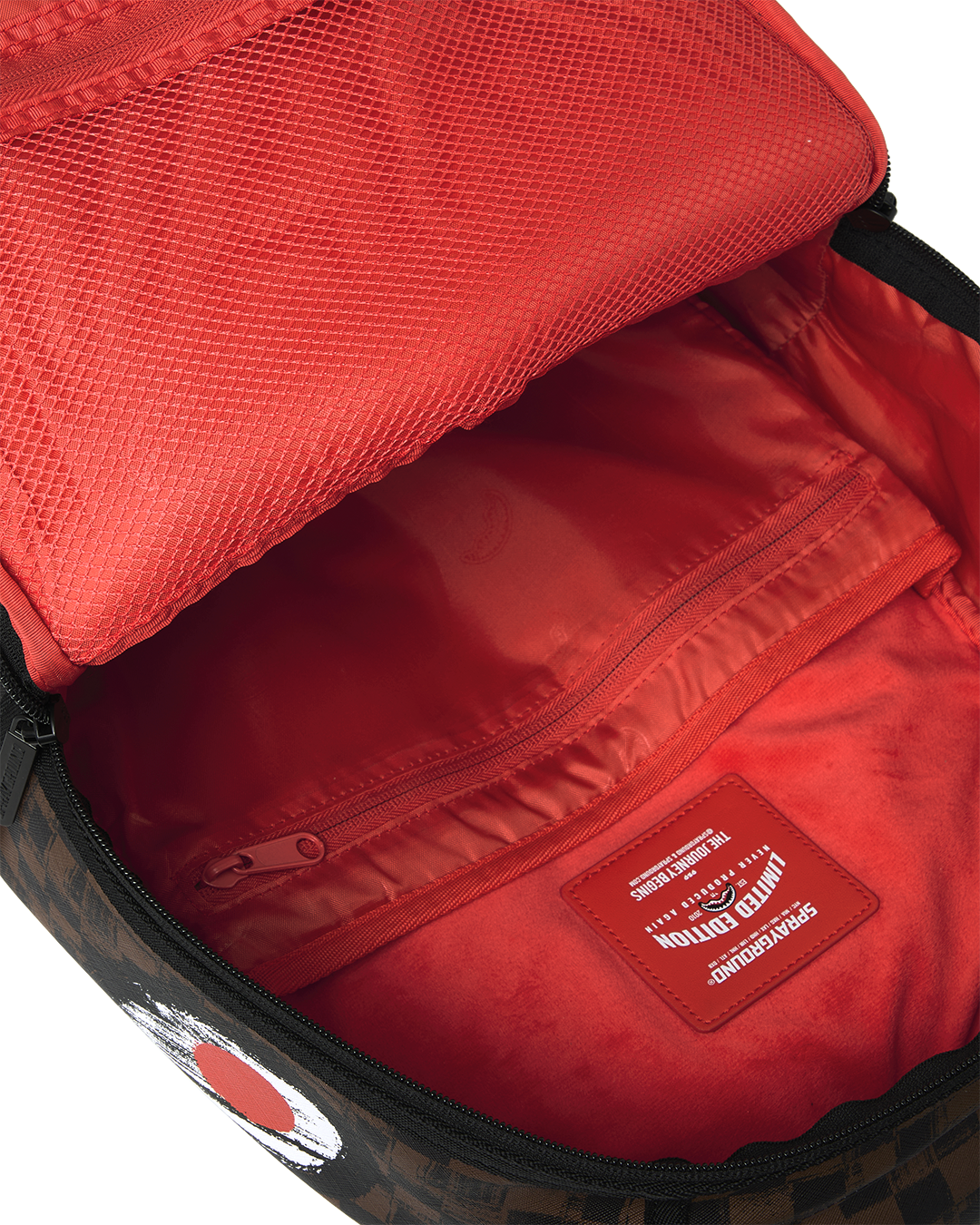 Sprayground backpack open top showing red interior lining and zip pocket