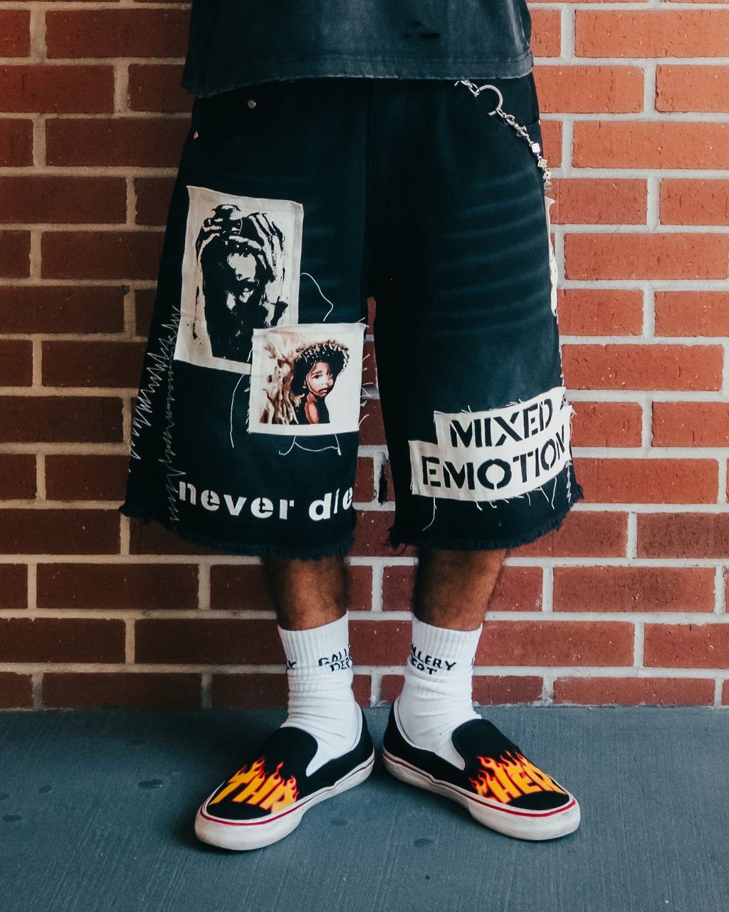 Men's black graphic carpenter shorts with large photo-style patches and text
