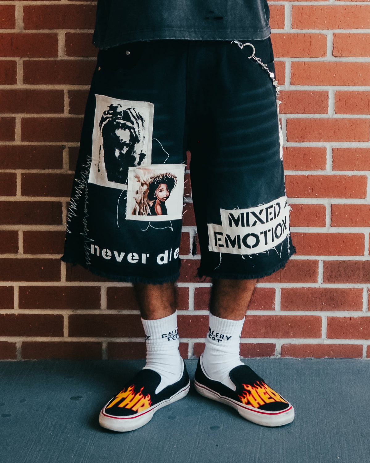 Men's black graphic carpenter shorts with large photo-style patches and text