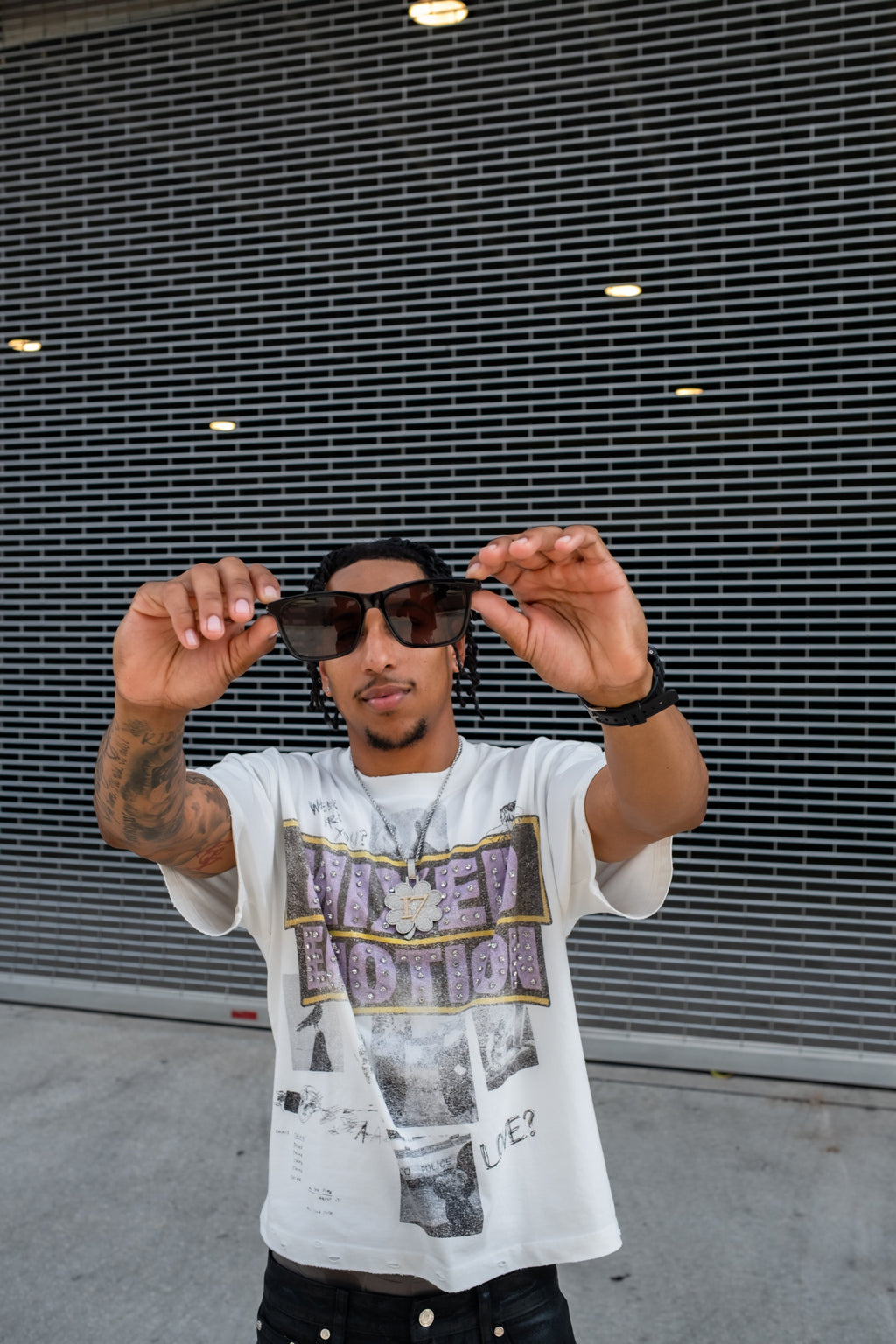 Men's white graphic T-shirt worn with sunglasses, front upper-body view