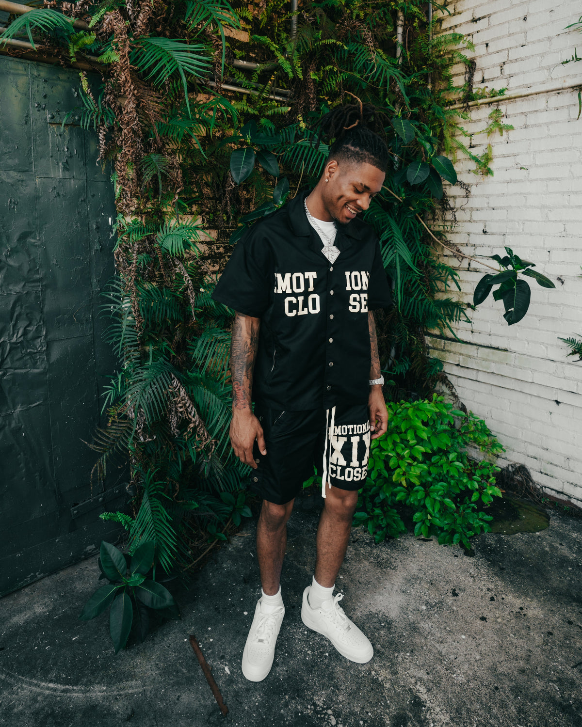 Men's black nylon shorts worn by model, bold front logo print and drawstring waist